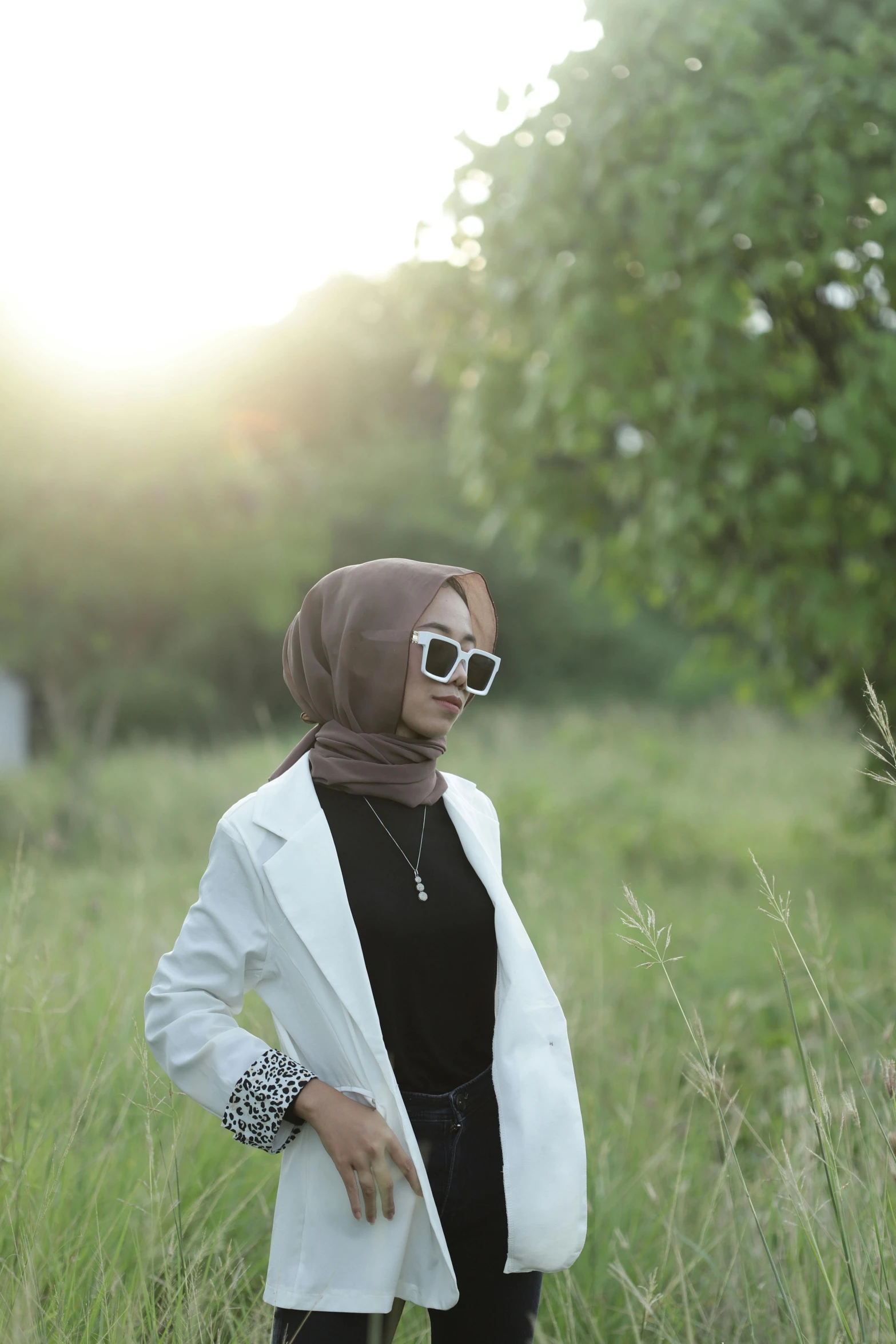 a woman in sunglasses and a white coat