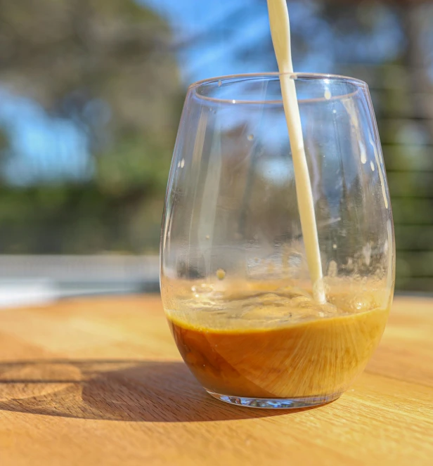 a tall glass filled with liquid is sitting on the table