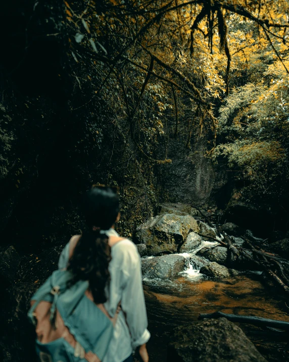 woman walking in front of a mountain river