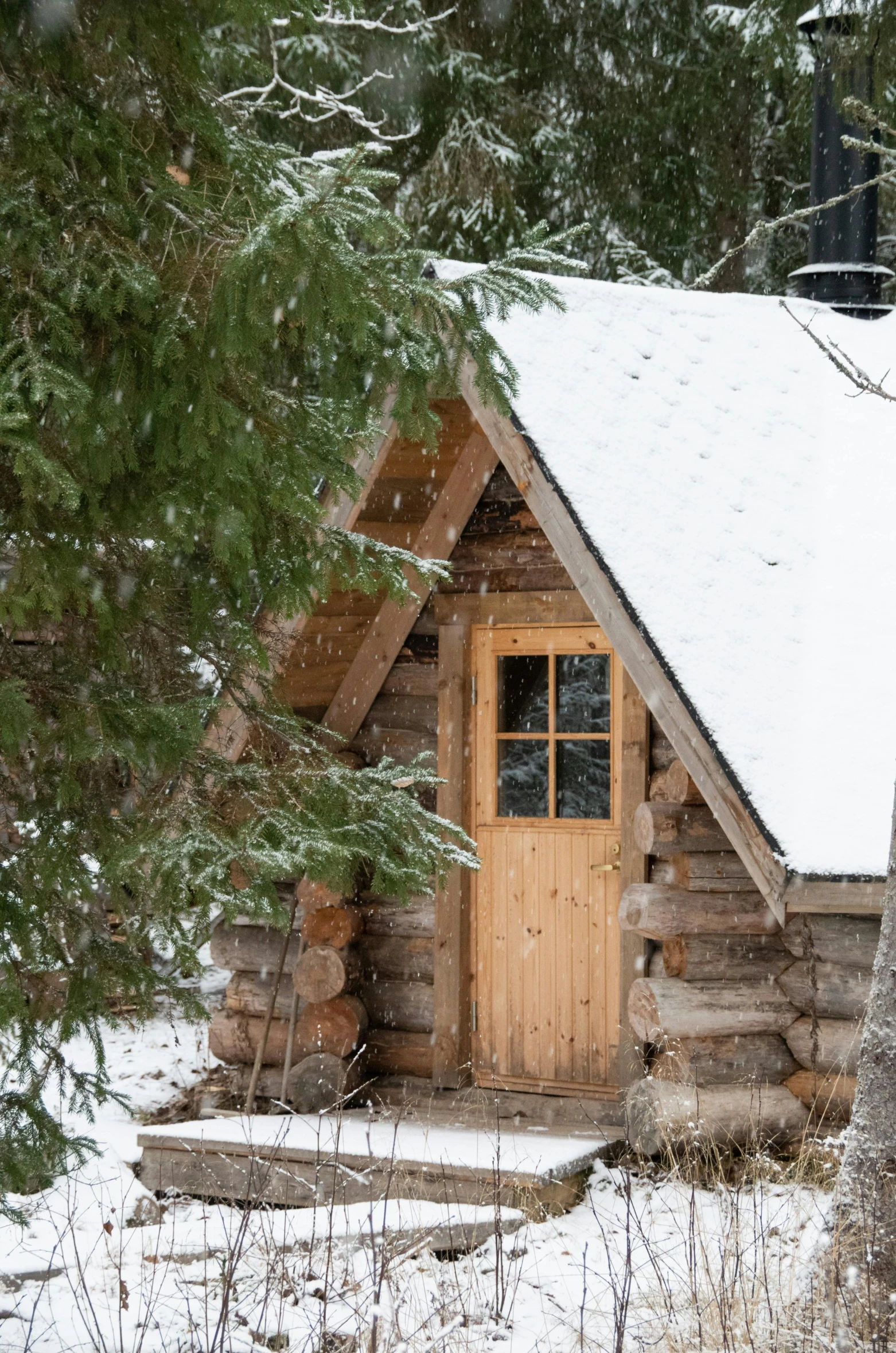 a cabin on snow covered ground next to trees