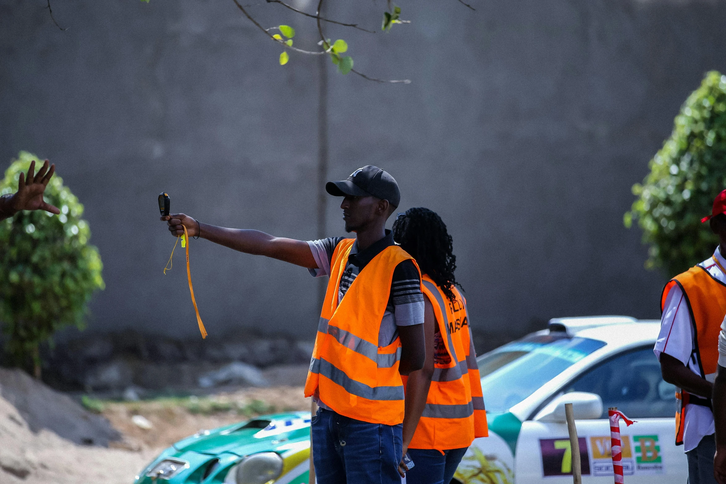 people in construction vests and safety jackets next to vehicles