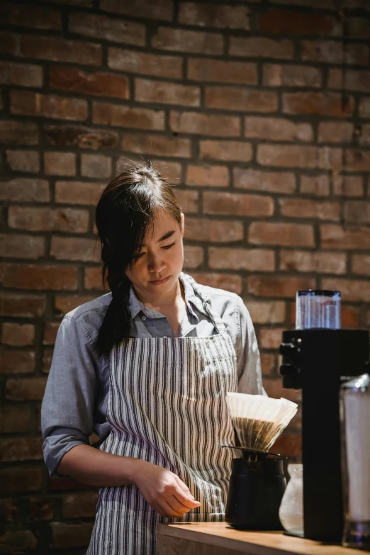 a woman standing behind a counter stirring soing