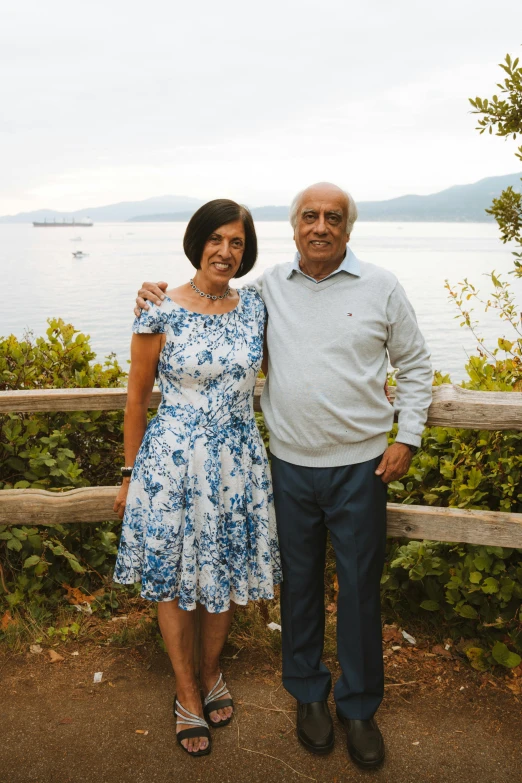 two people standing on a bridge overlooking a body of water