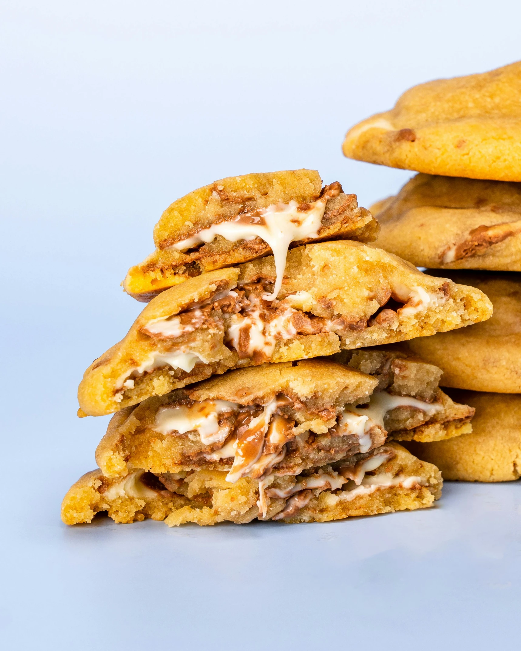 a stack of cookies with toppings on a light blue background