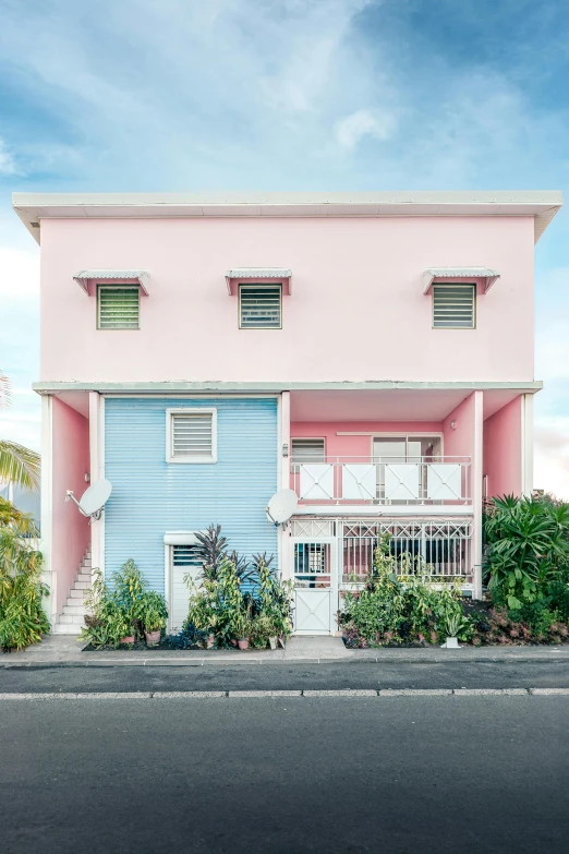 a blue and pink house is near a street