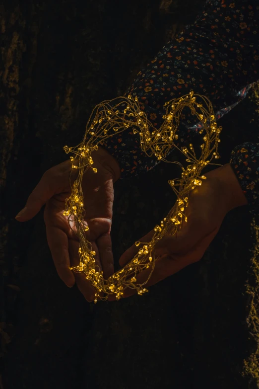 two hands holding a light up string