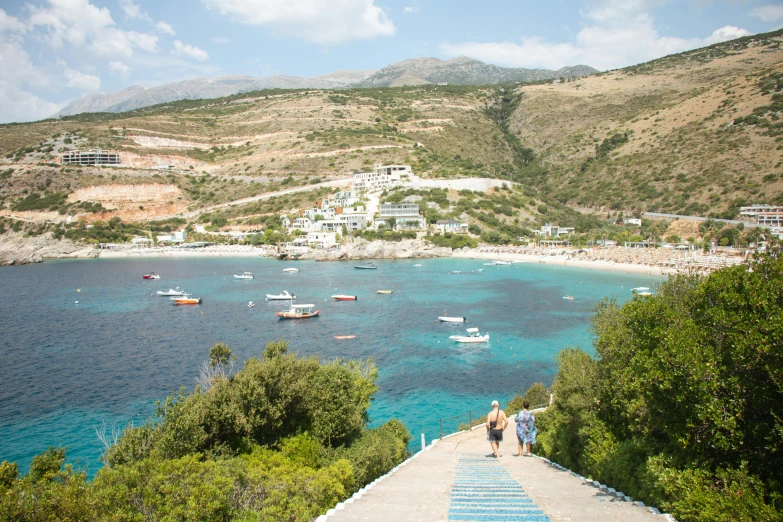 several boats in the water on a hill next to an ocean