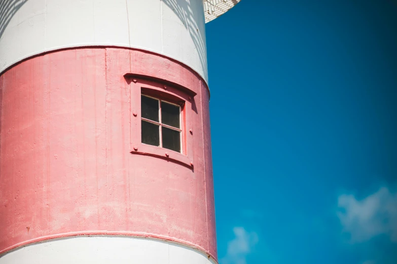 an old white and red tower with a sky background