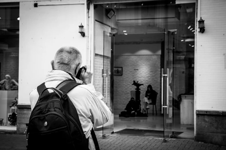 a man with a black backpack talks on his phone