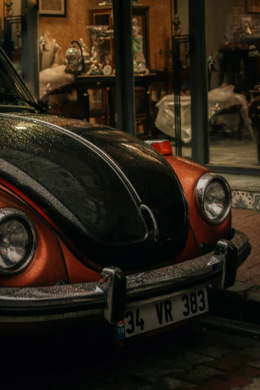 an orange beetle parked on the street near some glass jars