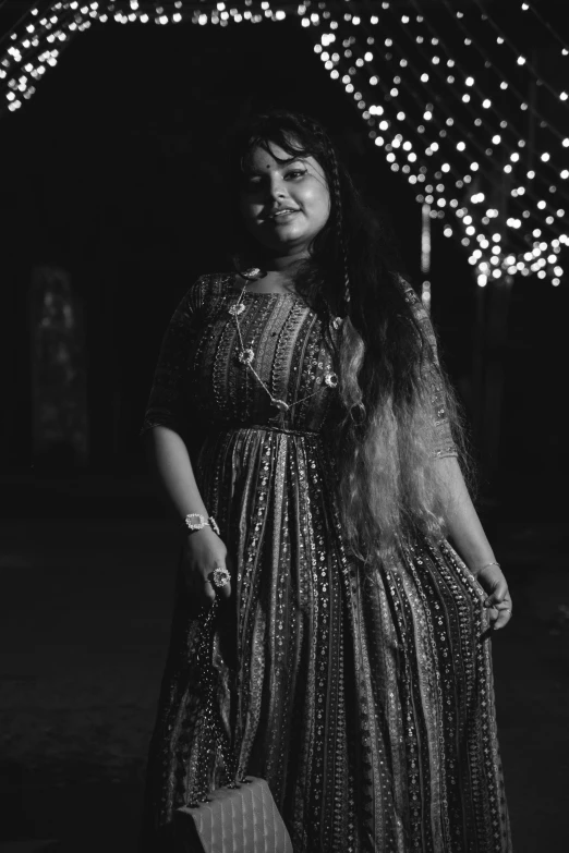 a woman standing next to some string lights