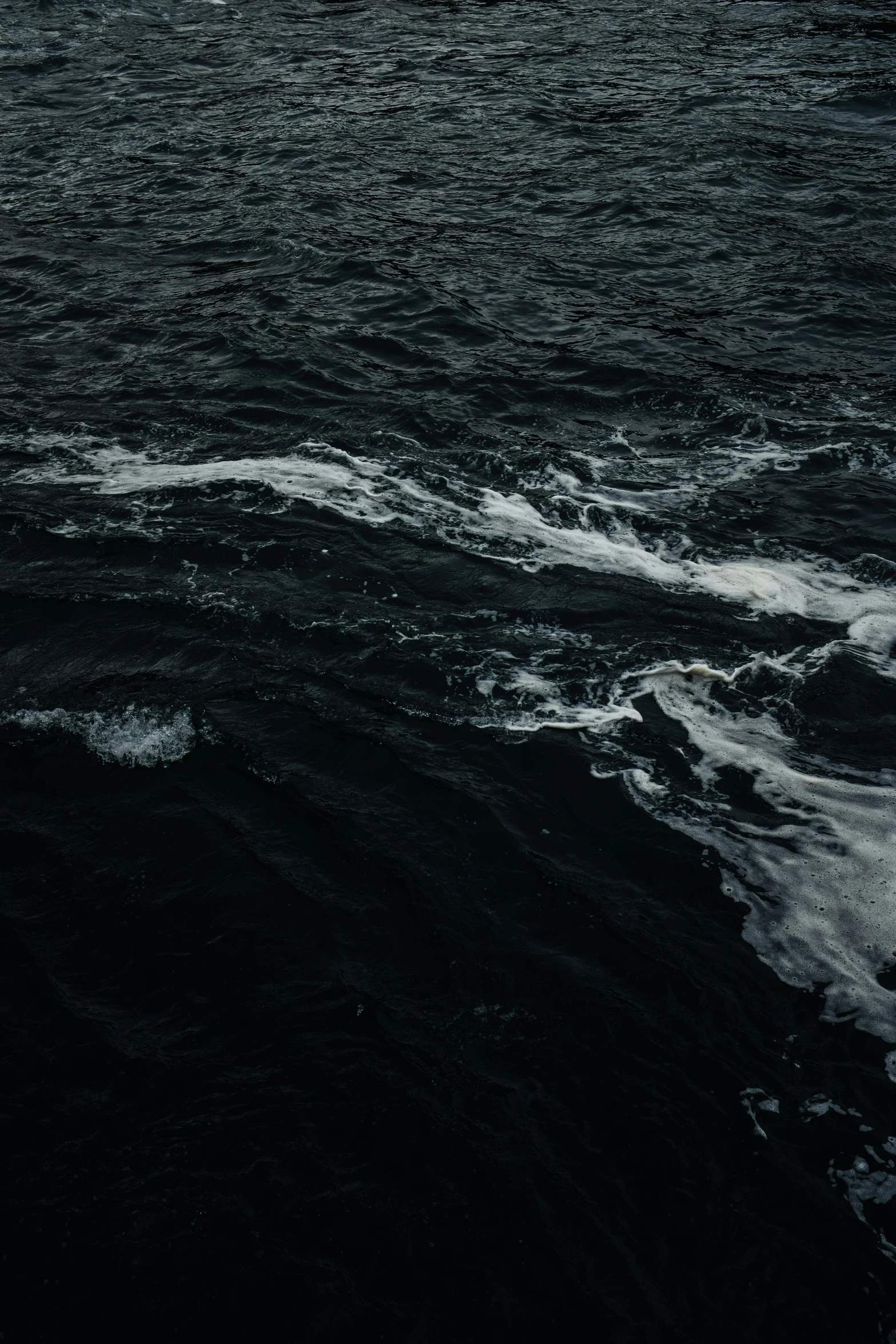 a small white boat sailing through a big body of water