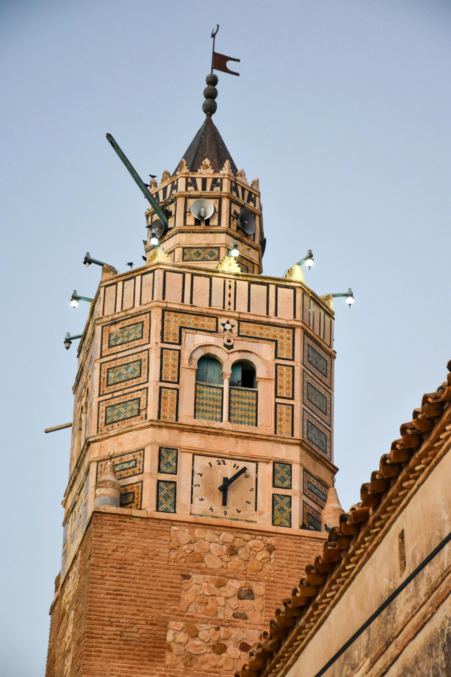 a clock tower with many small weather vane above it