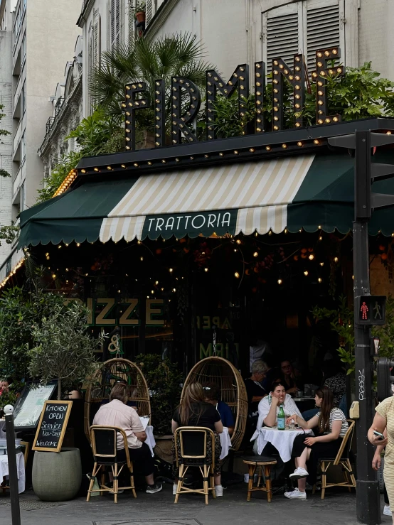 people sitting at tables in front of an italian restaurant