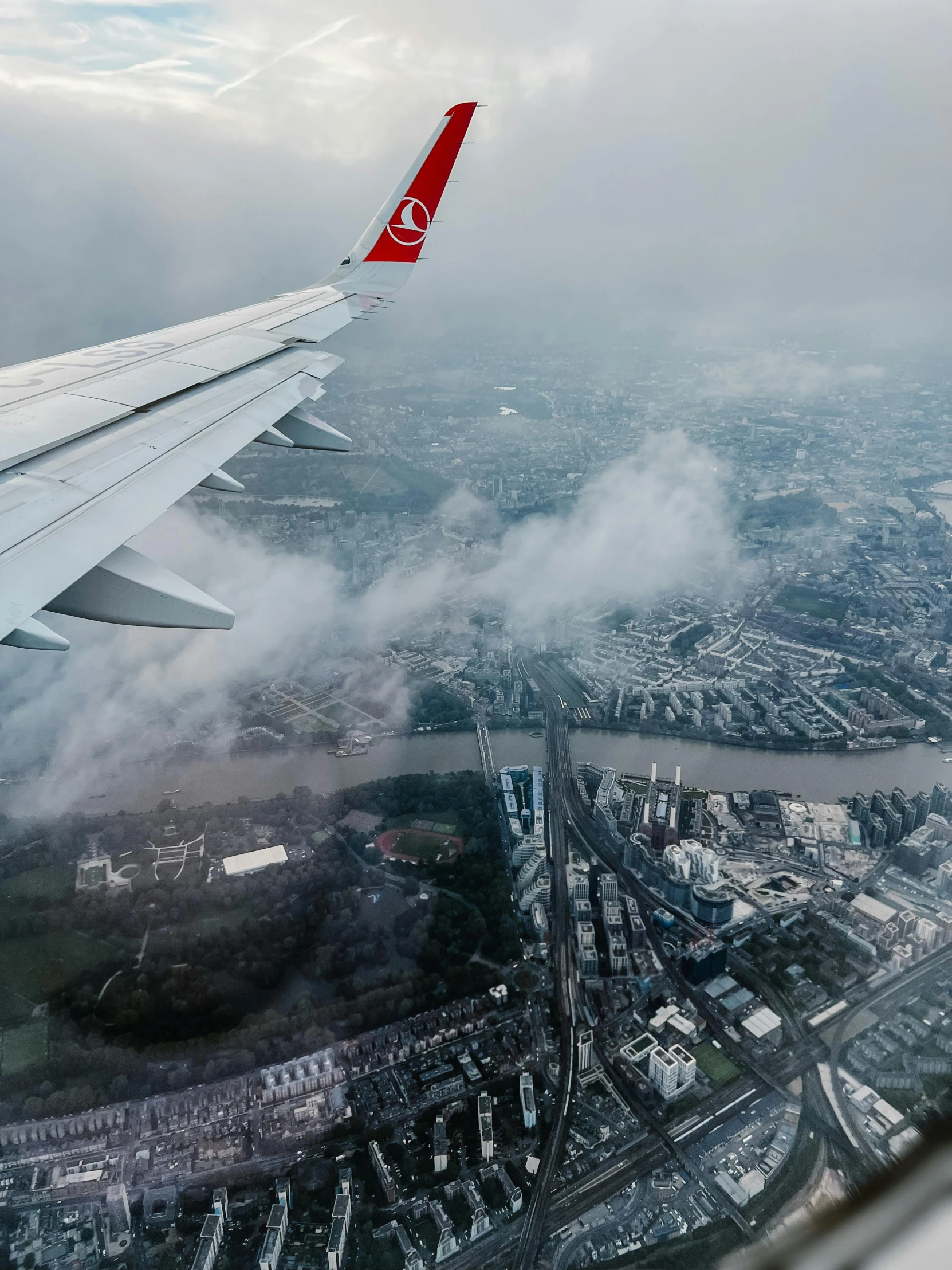 a view of an airplane wing flying through the clouds