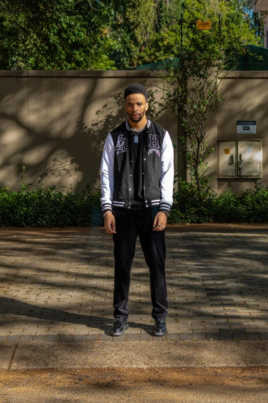 a man standing on the sidewalk in front of a tree