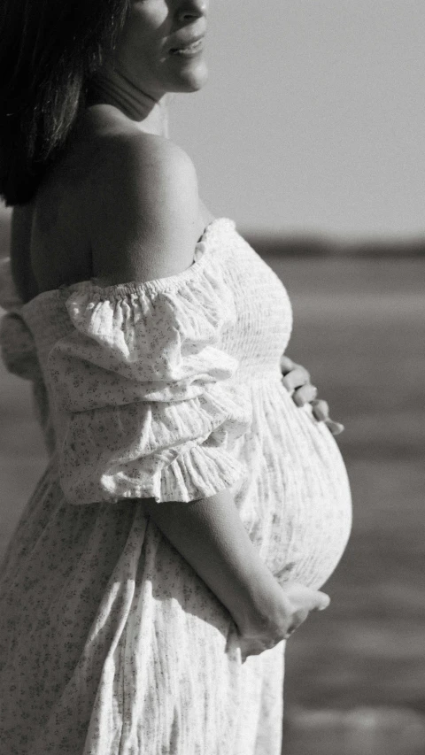 woman in off - shoulder dress on beach posing for picture