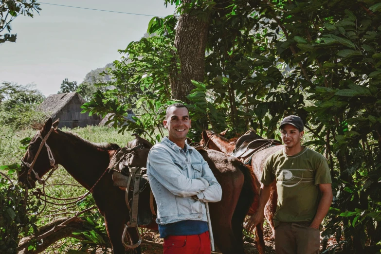 the two men are posing with their horses