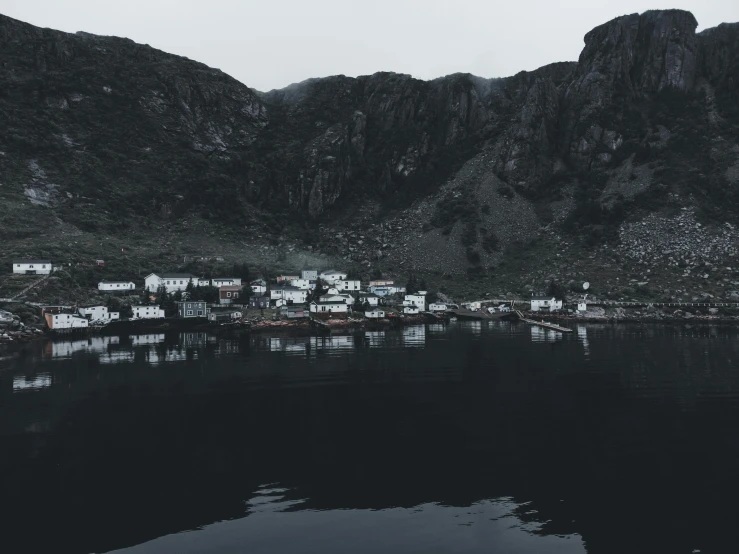 an image of some houses in the distance with mountains in the background