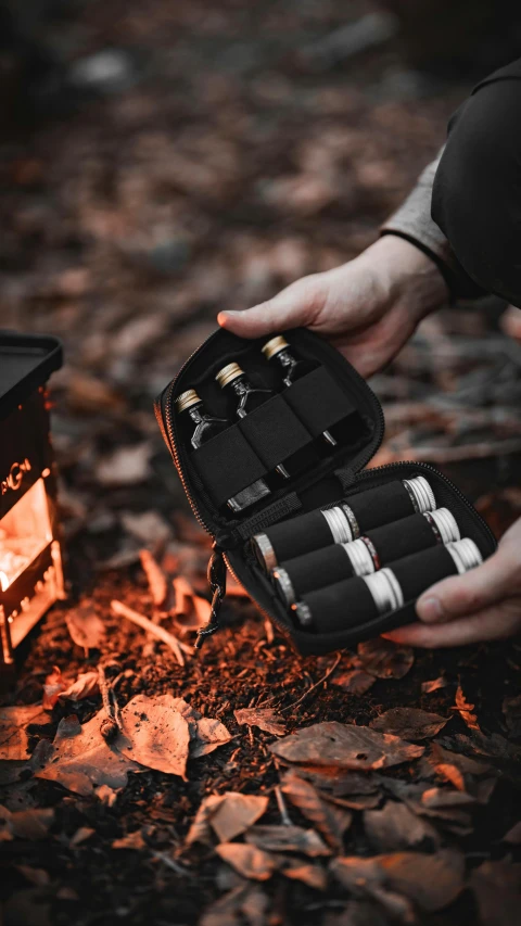 a person holding an open travel box with four lighters in it