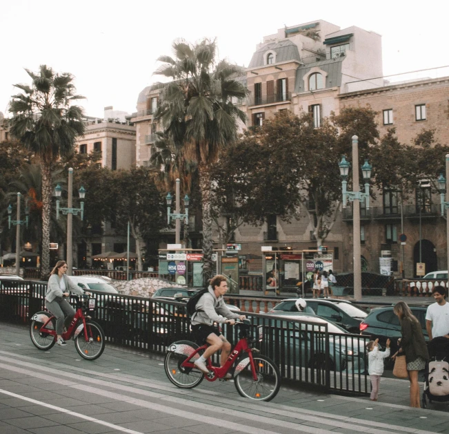 two men are riding bikes on the sidewalk