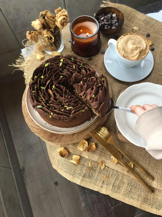 a chocolate cake and coffee with two plates around