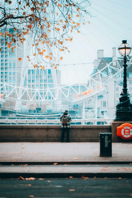 a person standing next to the road looking out at the city