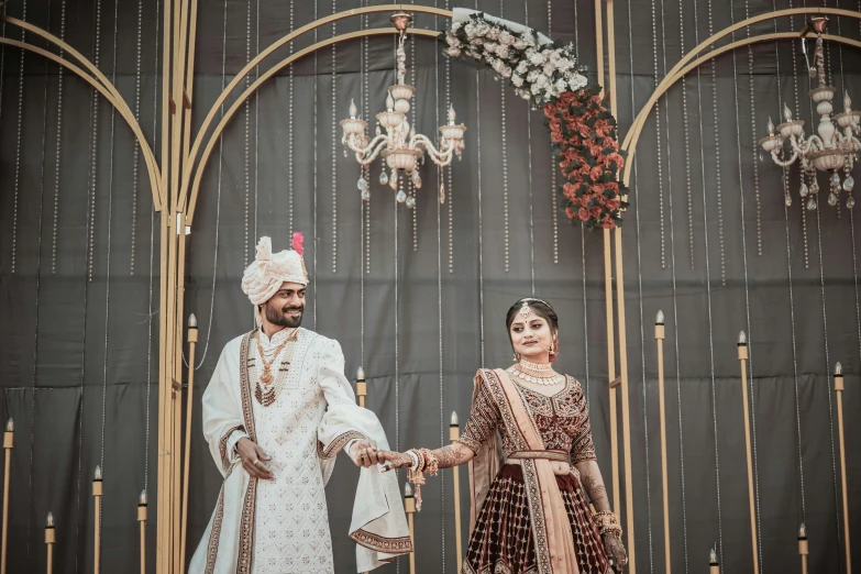 an indian couple on stage dressed in fancy clothing