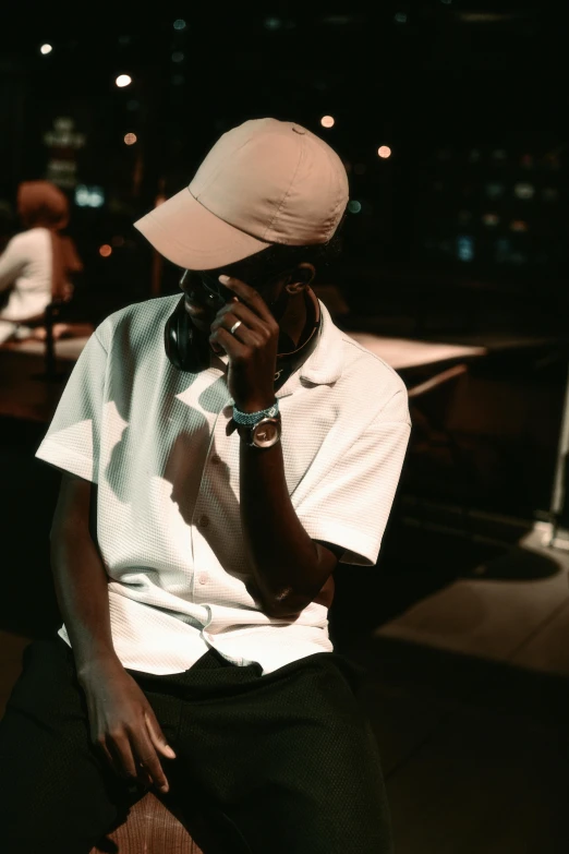 a man wearing a white shirt, hat, and black pants