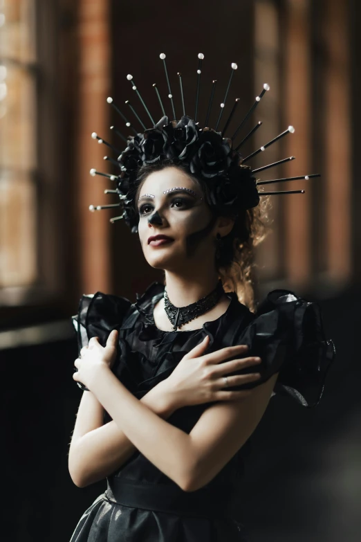 a woman in black and silver wearing spike headpieces