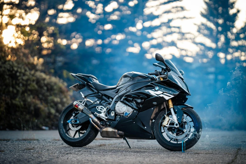 a black motorcycle is on a road by some trees