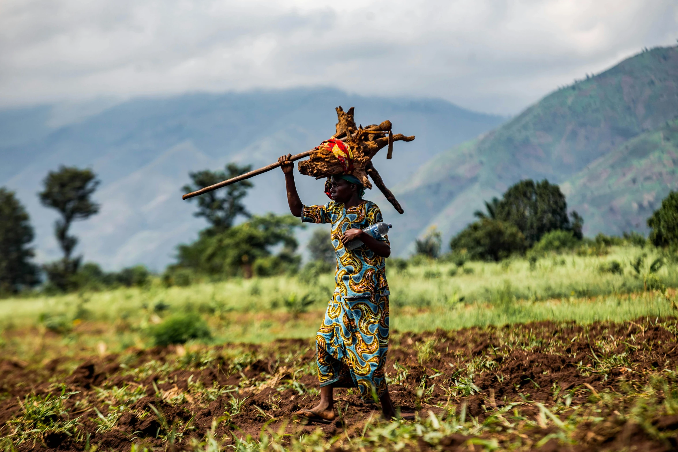 a young person carrying soing in their hands over her head