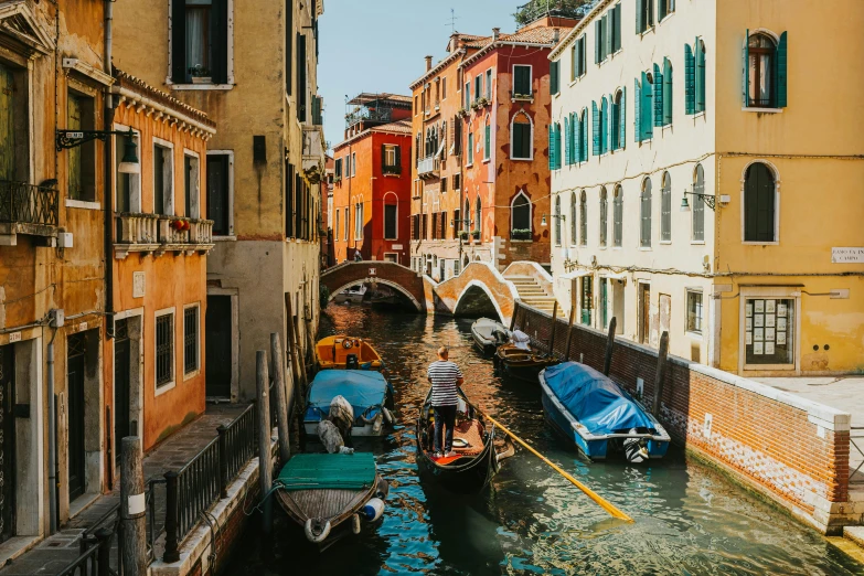 a canal with several boats next to buildings