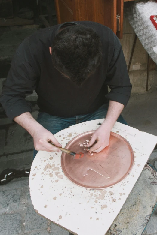 a man that is in front of some pottery