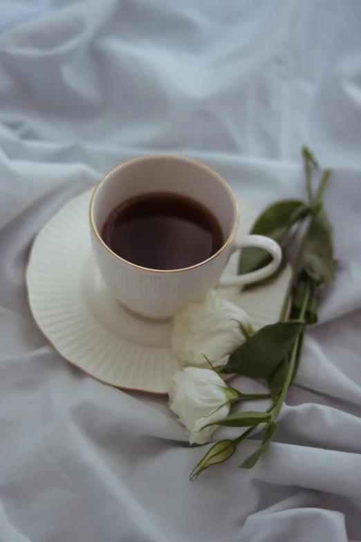 a cup of coffee and a white flower