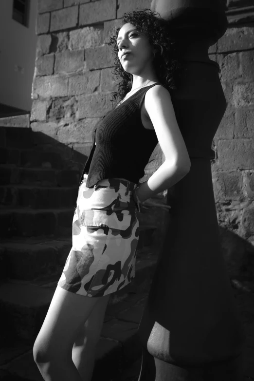 a beautiful woman standing next to some brick buildings