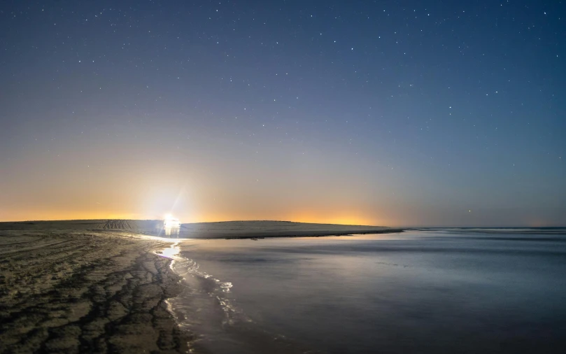 there is a beautiful view of a night sky at the beach