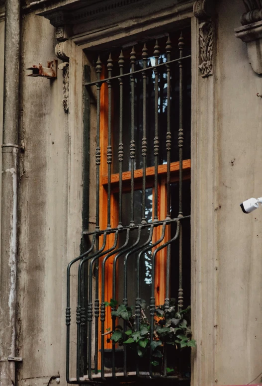 the orange bars in the window of a stone building