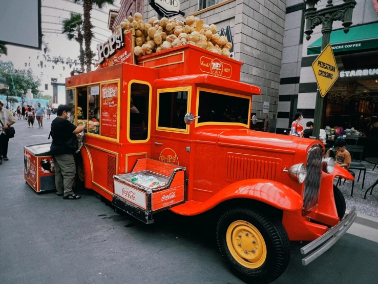 orange and yellow truck on road with people standing near by