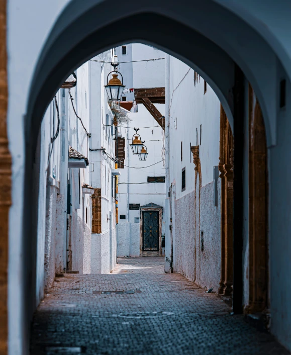 an alley that is empty and has an arched doorway