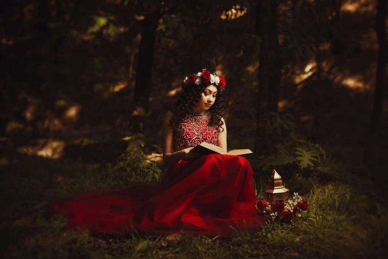 a woman is sitting in the forest reading a book