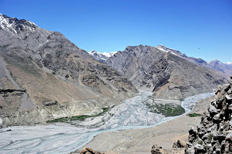 a mountain view with mountains and a river running through it