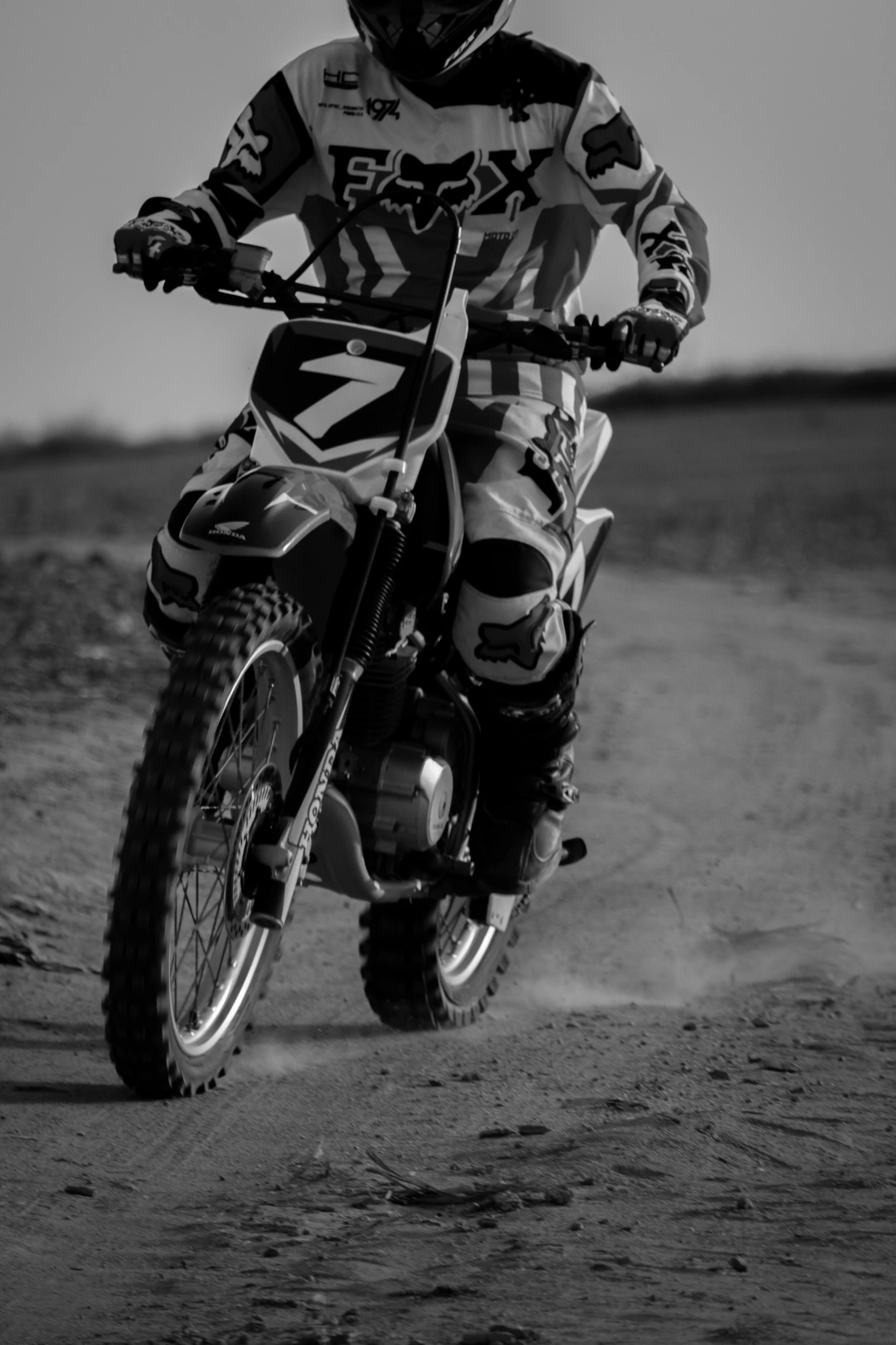 a man is riding a dirt bike in the sand