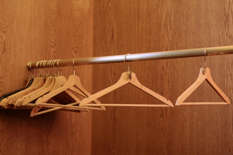three wooden clothes hangers hanging from a wall