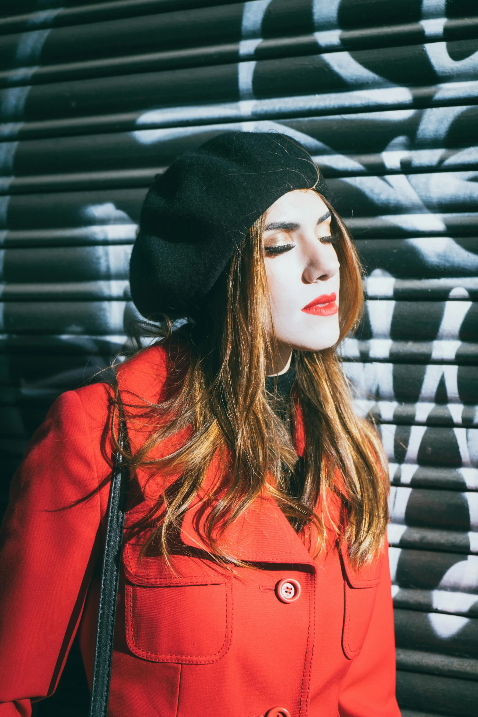 a woman with long hair and red lipstick wearing a black beret