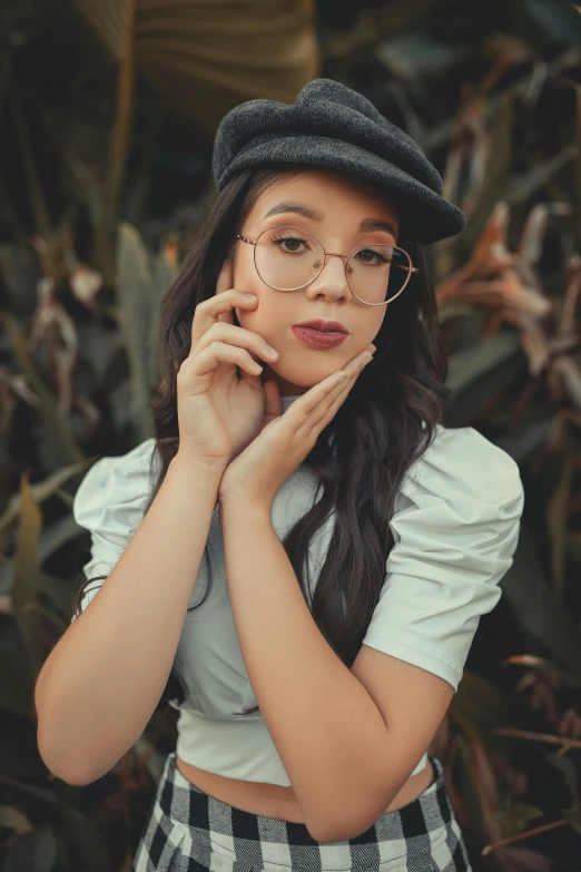 a woman with long hair wearing glasses and a hat