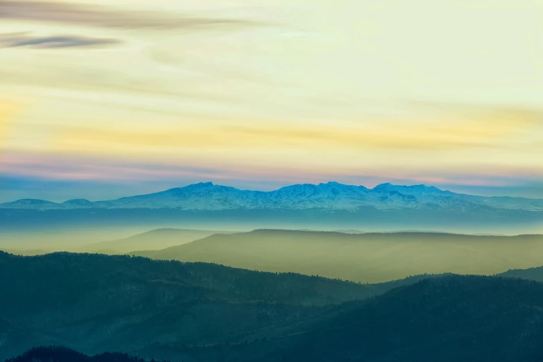 a very colorful sky is over a bunch of mountains