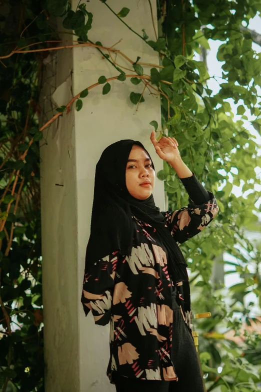 a women standing outside in a floral dress and head scarf