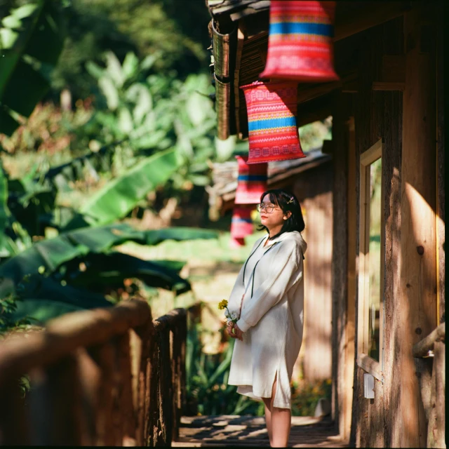 woman in a kimono is standing on a porch