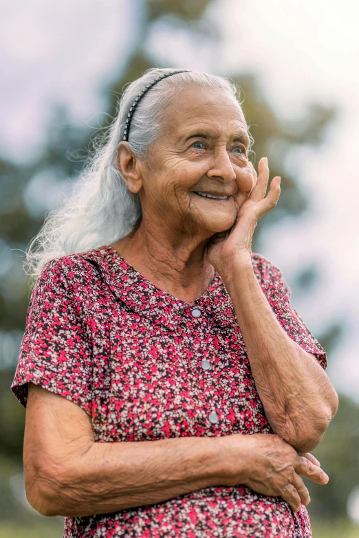 an old woman standing with her hands together